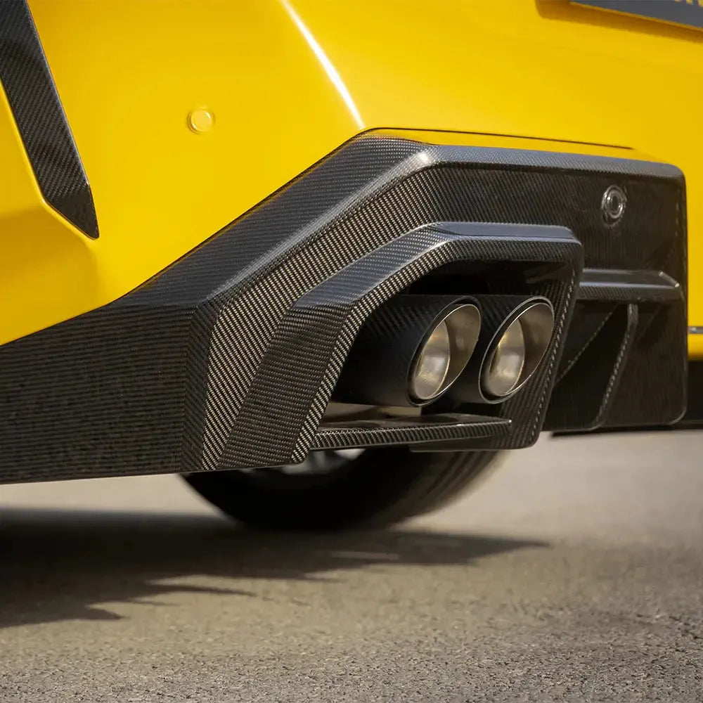 Yellow BMW G90 M5 rear corner close-up, with 2 fitted carbon exhaust tip covers