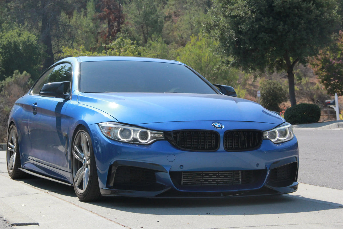 Kék BMW F32 első háromnegyed nézetből, felszerelt carbon felső lökhárító splitterekkel