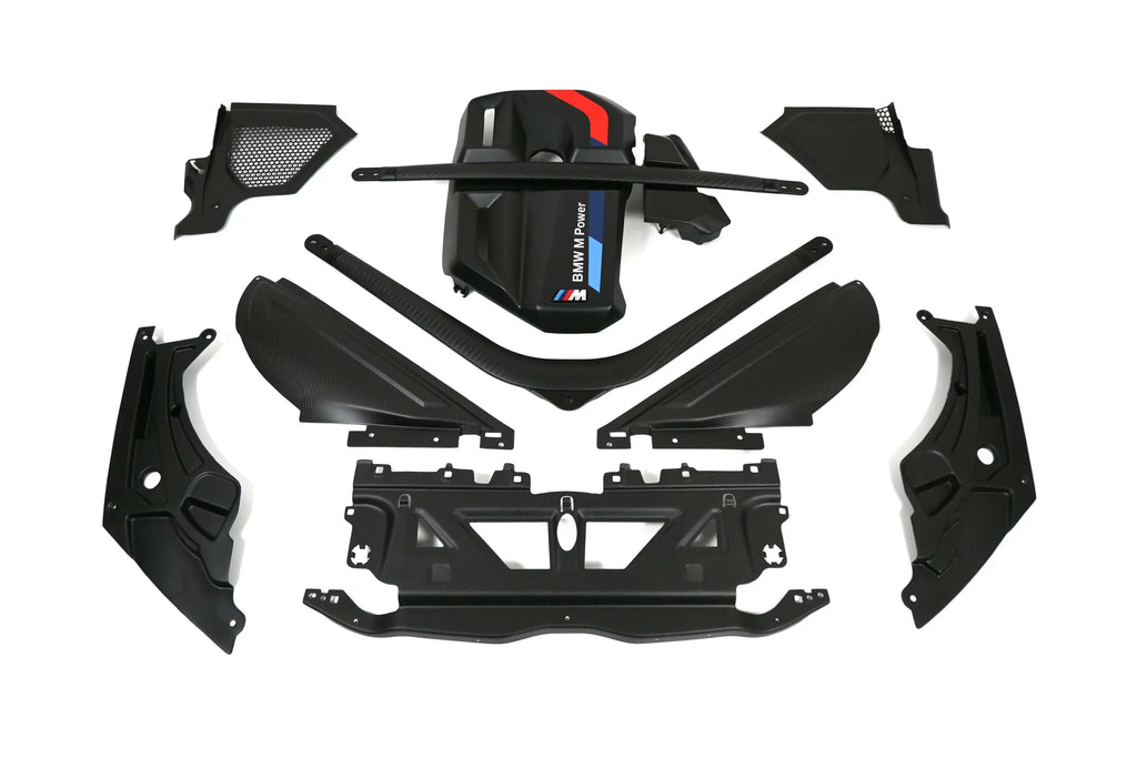 Engine bay of a black BMW G80 M3 with carbon fiber covers and red and blue M Power trim