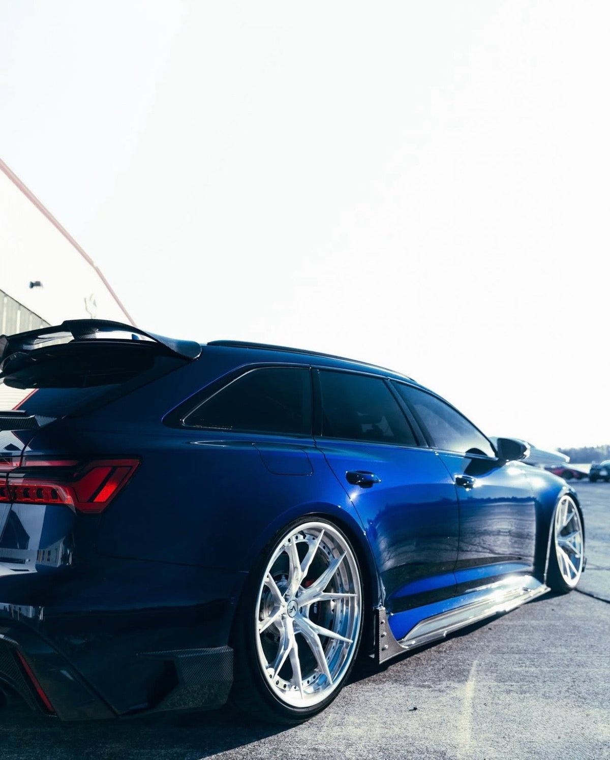 Blue Audi RS6 Avant C8, low rear three-quarter view, with fitted carbon side skirt (Euro V1 Style)