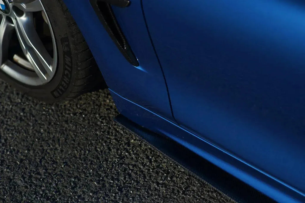 Kék BMW F32 carbon oldalsó szoknyájának eleje a kerék mögött, közelről (MP Style)