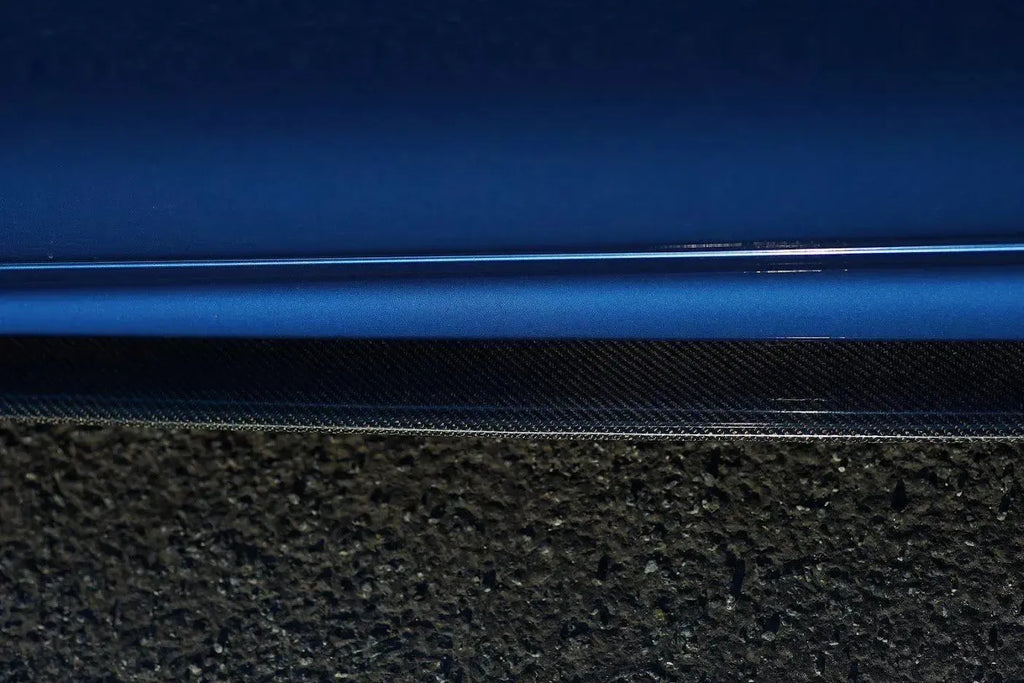 Carbon oldalsó szoknya toldat a kék BMW F32 ajtaja alatt, közelről (MP Style)