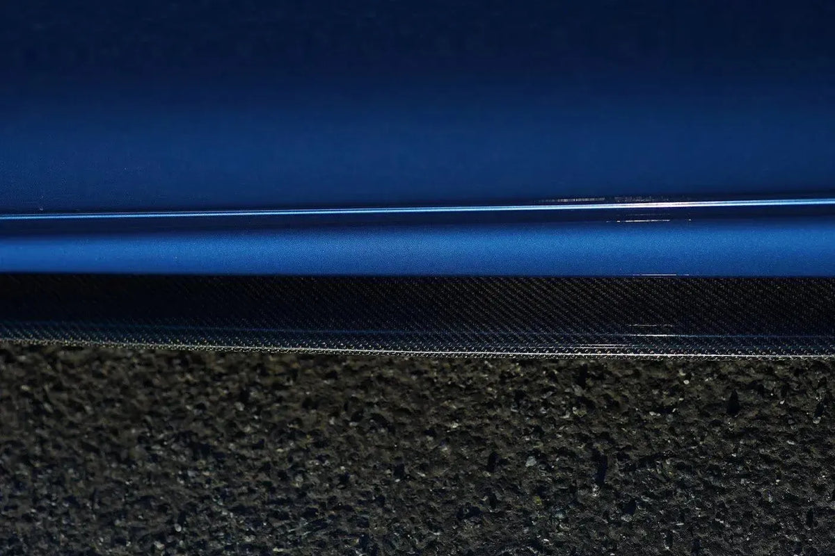 Carbon oldalsó szoknya toldat a kék BMW F32 ajtaja alatt, közelről (MP Style)