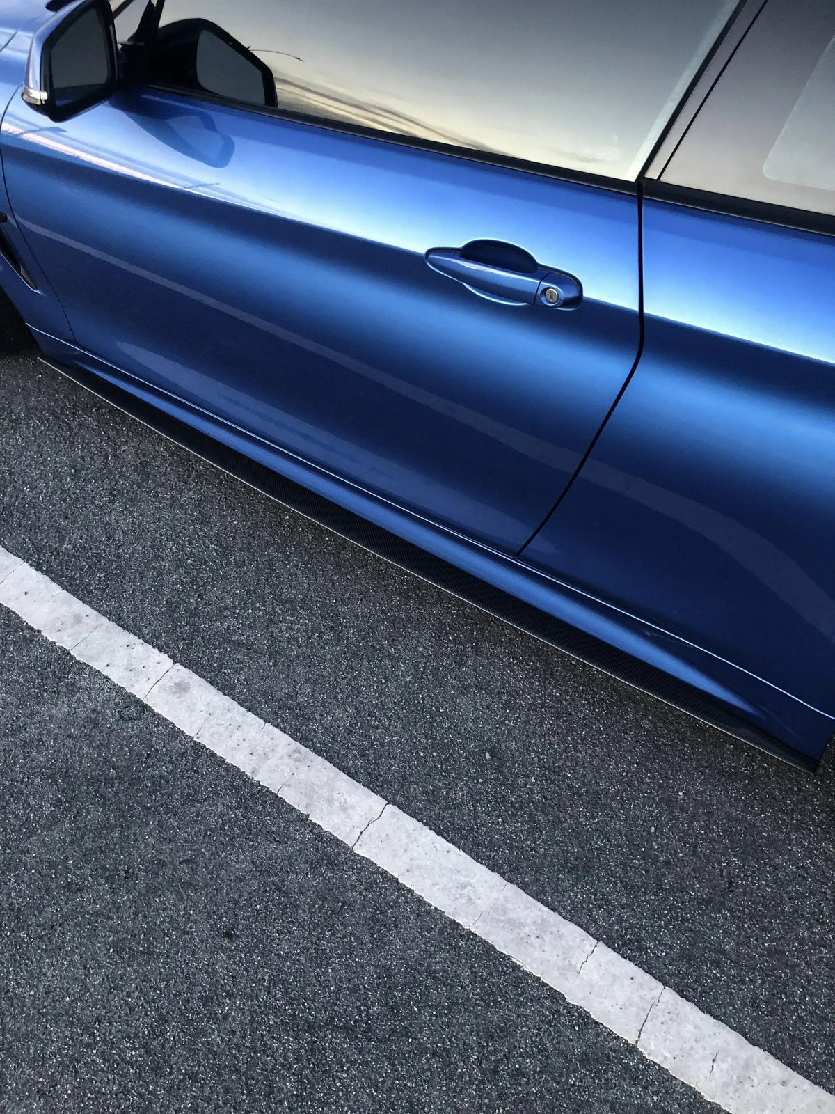 Kék BMW F32 oldala alacsony szögből, felszerelt carbon oldalsó szoknyával (MP Style)