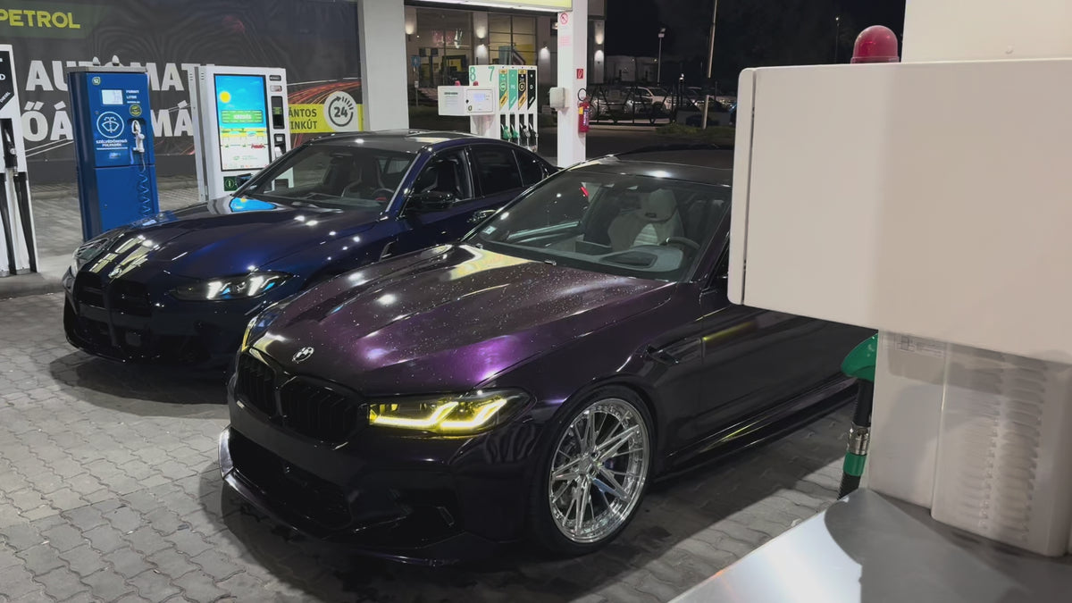 Két BMW éjszaka egy benzinkútnál, sárga DRL fényekkel