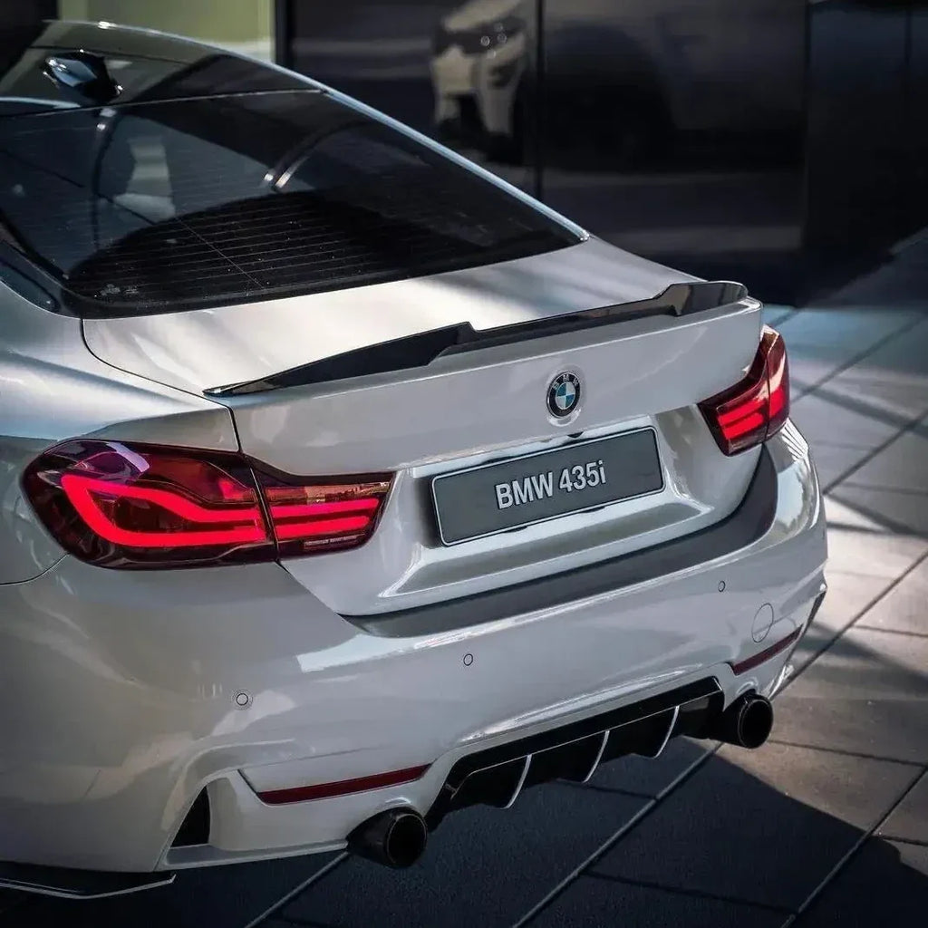 Fehér BMW F32 435i hátsó háromnegyed nézetből, carbon csomagtartó spoilerrel (M4 Style)