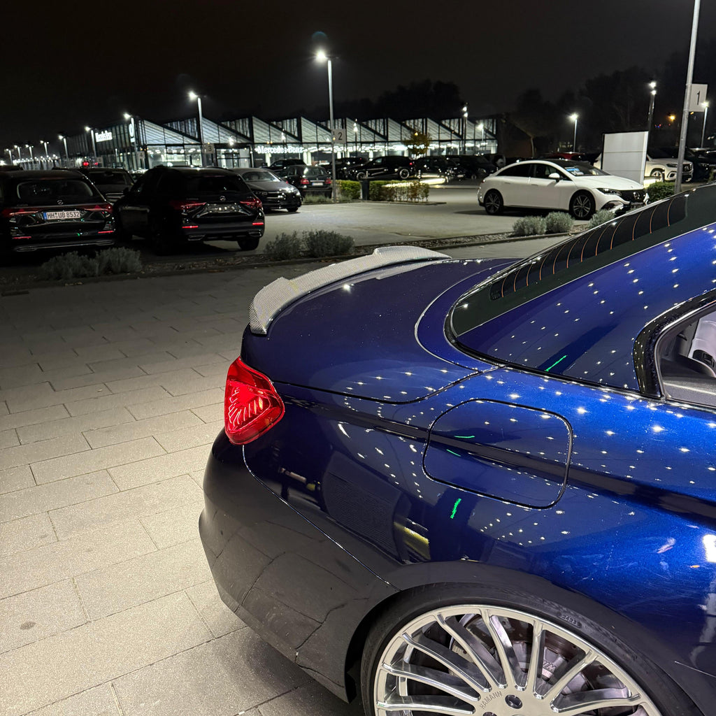 Kék BMW F83 M4 kabrió hátsó része közelről este, felszerelt carbon spoilerrel (M4 Style)