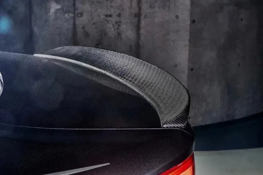 Close-up of the carbon trunk spoiler corner on a dark car in a garage (3D Style) – BMW F90 M5 and G30 5 Series
