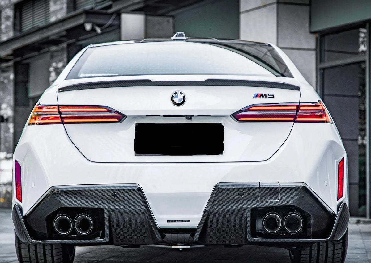 White BMW G90 M5 rear view, with fitted carbon trunk spoiler (MP Style)