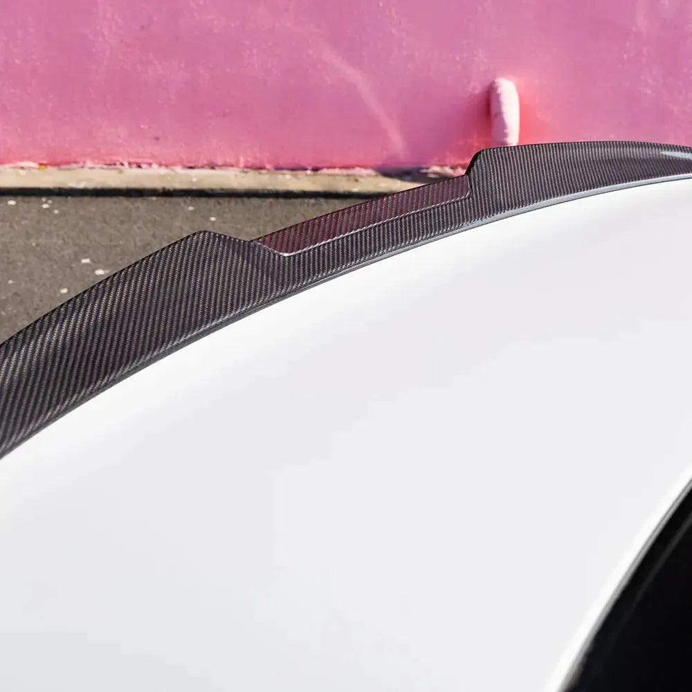Close-up of the carbon fiber trunk spoiler's stepped wingtip profile, on a white BMW G90 M5 (SQ Style)