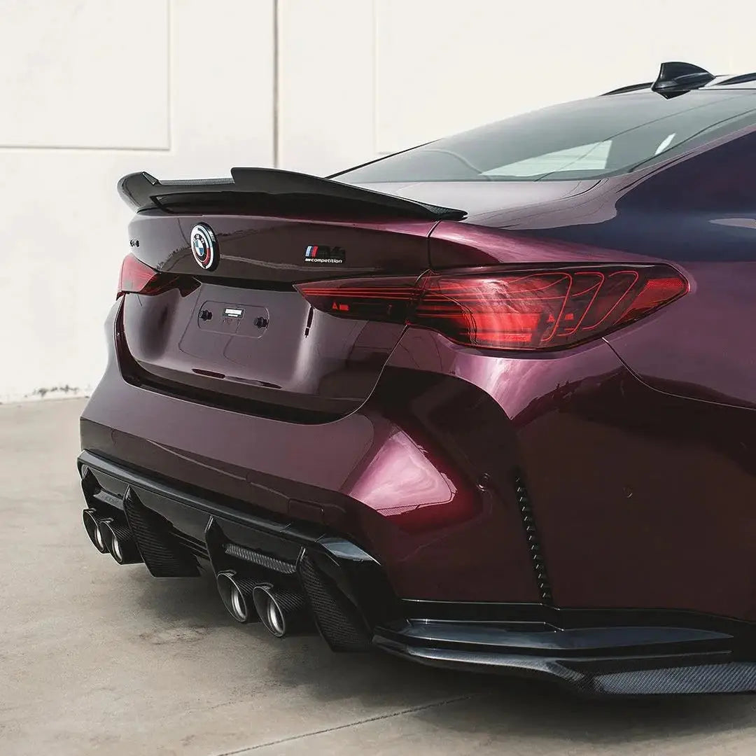 Hátsó nézet egy fényes bordó alfa romeo giulia quadrifoglio szárny spoiler fekete carbon fiber bmw m3 kipufogó rendszerhez