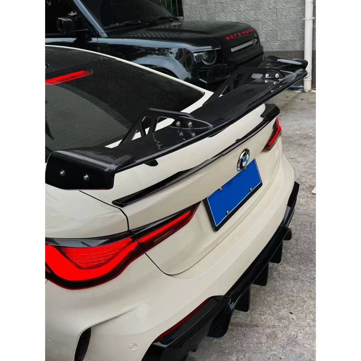 Carbon fiber rear wing close-up on a white car (AD V2 Style) – BMW G87 M2