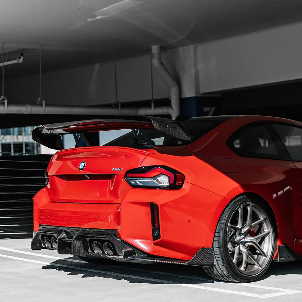 Rear of a red BMW G87 M2 with carbon fiber rear wing (AD V3 Style)