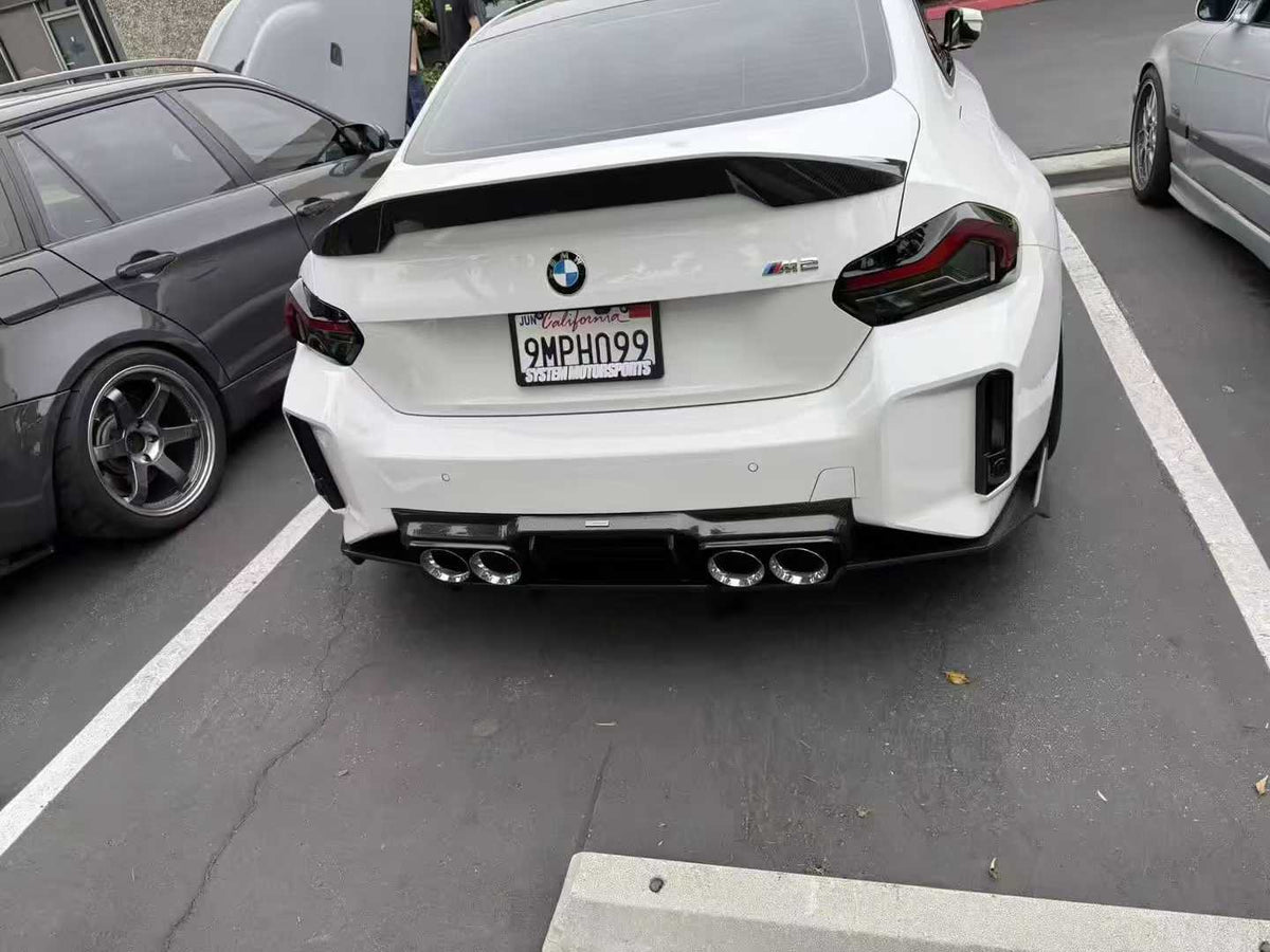 Rear of a white BMW G87 M2 with carbon fiber spoiler (C Style spoiler)