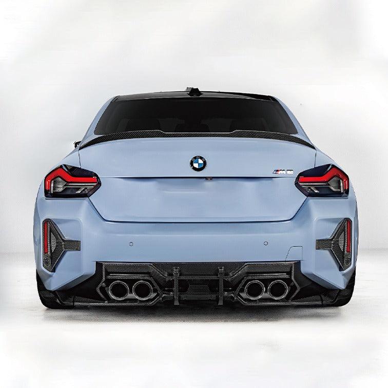 Rear of a light blue BMW G87 M2 with small carbon fiber spoiler (Small carbon spoiler)
