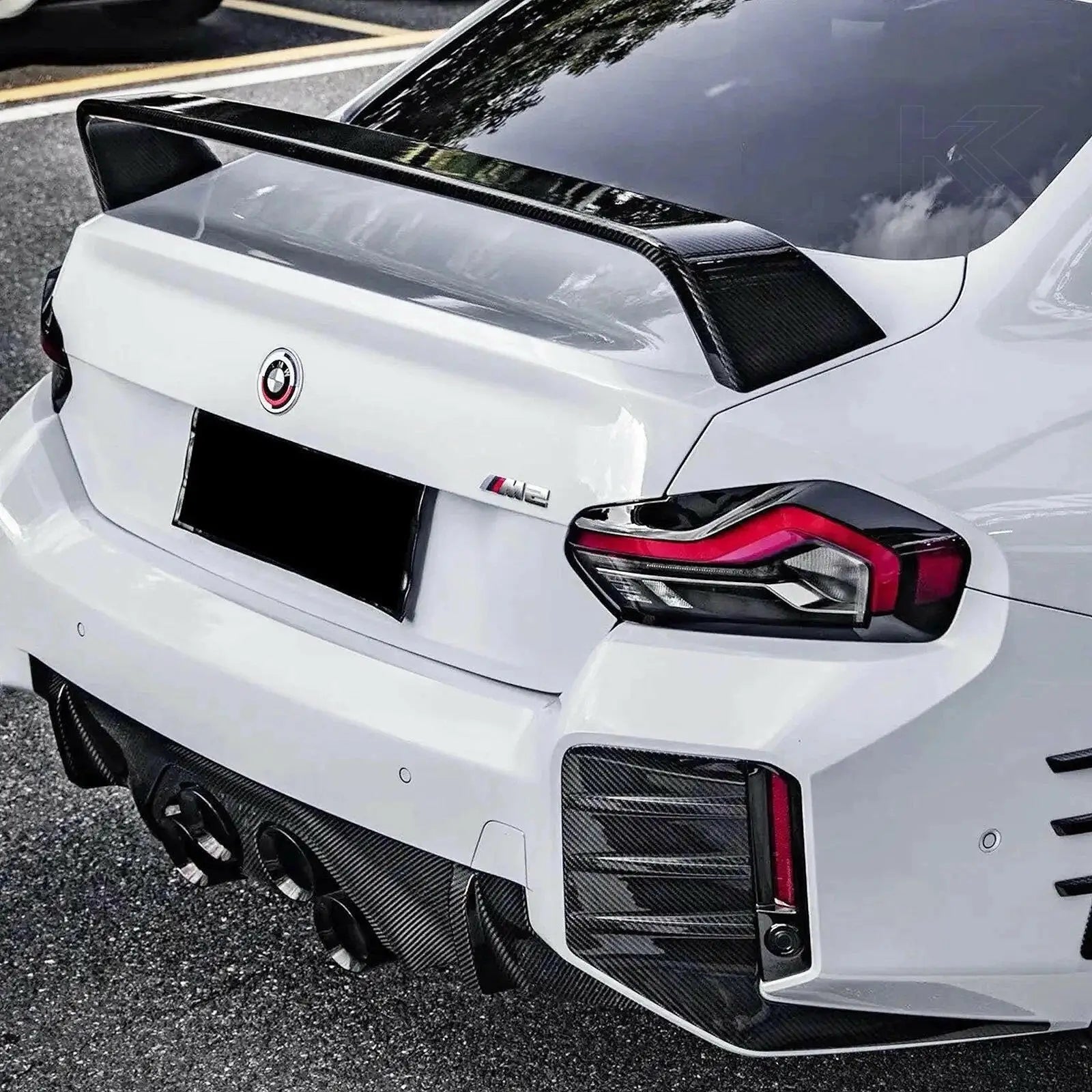 Fehér bmw m4 fekete carbon fiber hátsó szárnnyal és diffúzorral a bmw m3 kipufogó rendszerrel