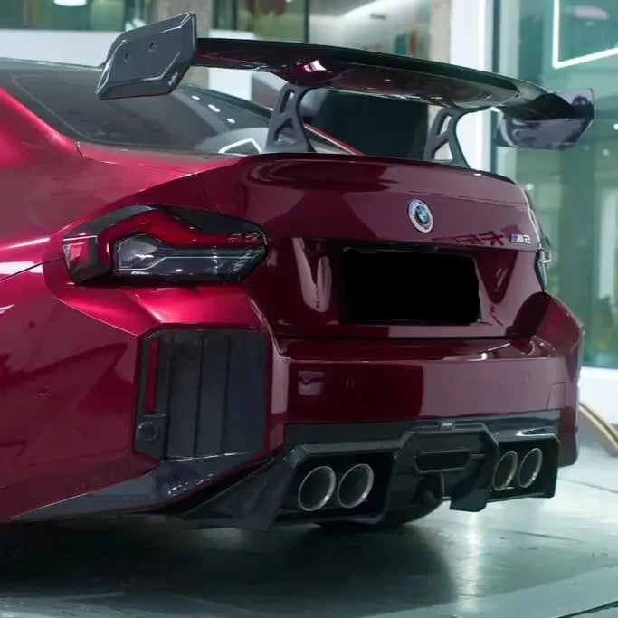 Glosszpiros bmw m2 hátsó része fekete carbon fiber szárnnyal és kipufogó rendszerrel a szárnyak carbon fiber bmw g87 m2 termékből