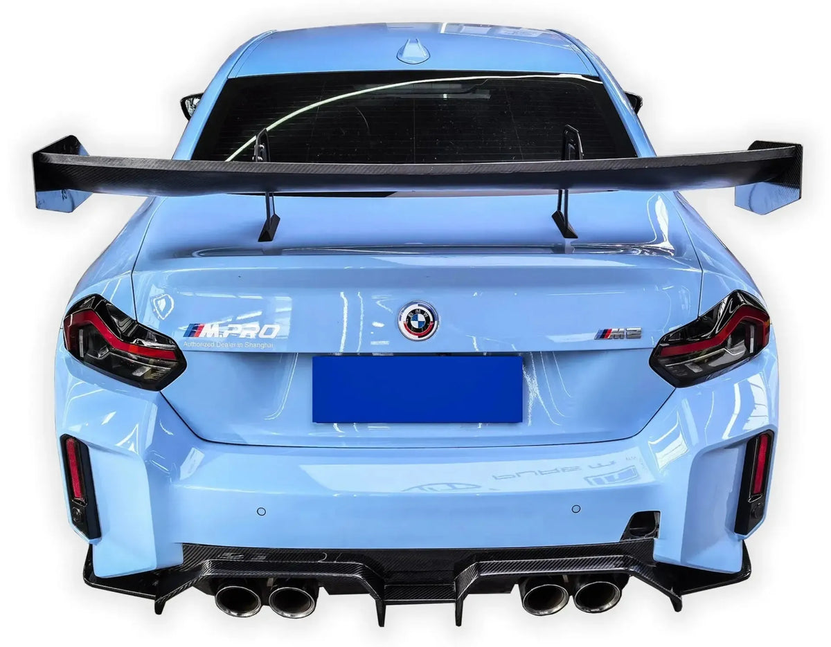 Rear of a light blue BMW G87 M2 with carbon fiber rear wing (Signature Style wing)