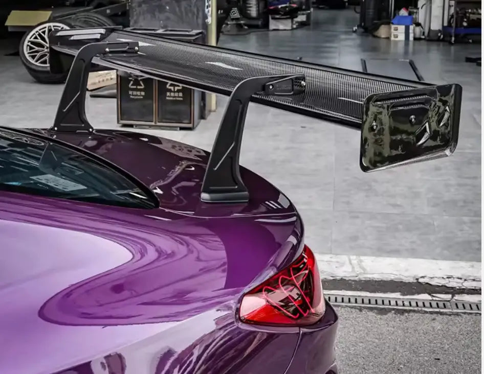 Fekete carbon fiber szárny hátulnézetből lila bmw g87 m2 autóra kipufogó rendszer mellett