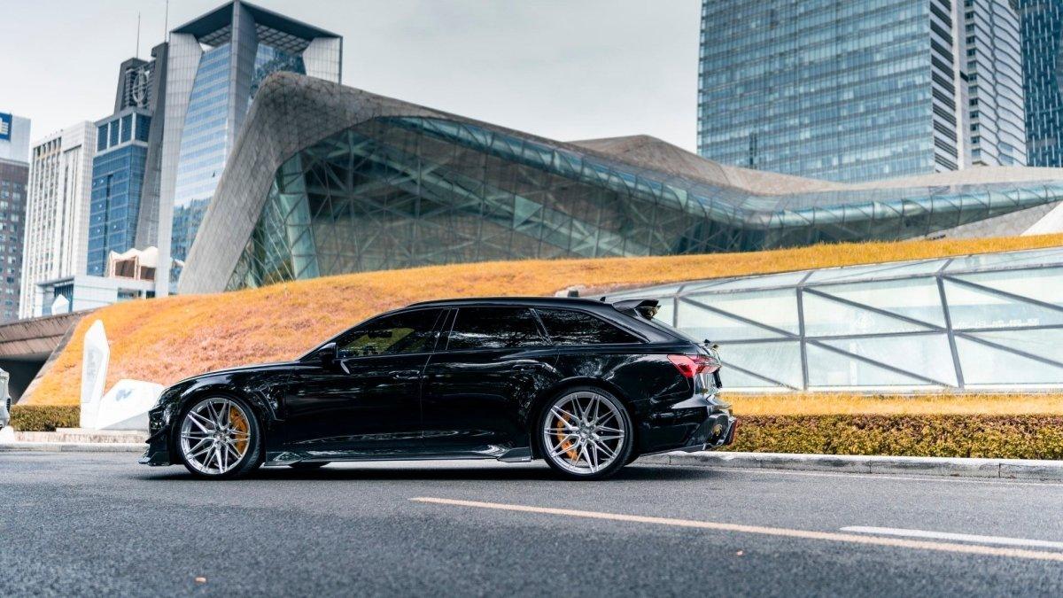 Fekete Audi RS6 Avant C8 oldalprofilja városi környezetben, háromrészes carbon tetőspoilerrel (KB Style)