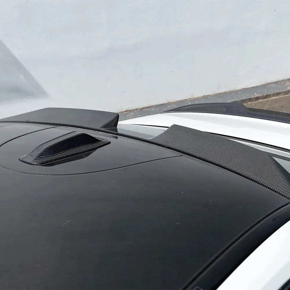 Close-up of a white BMW G90 M5 roof with the carbon roof spoiler above the rear window (SQ Style)