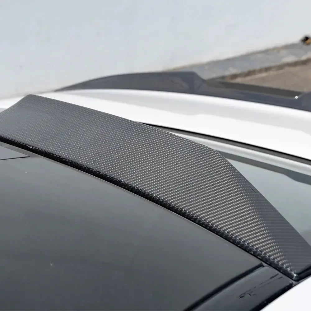 Close-up of the roof spoiler end, with visible carbon weave, on a white BMW G90 M5 (SQ Style)