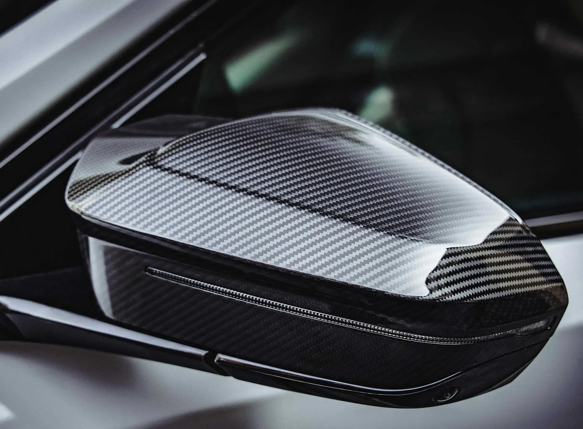 Fényes carbon tükörborítás közelről fehér BMW G90 M5-ön (M Style)
